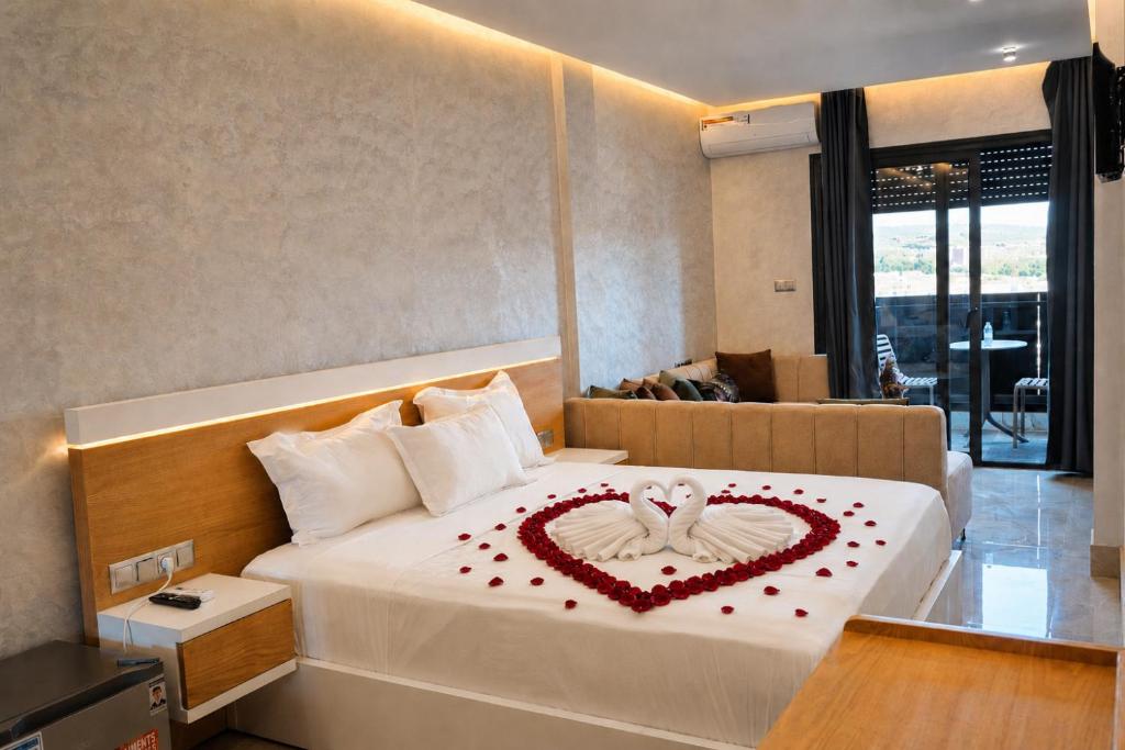 a hotel room with a bed with a heart made out of roses at Hôtel Aguelmam in Khenifra