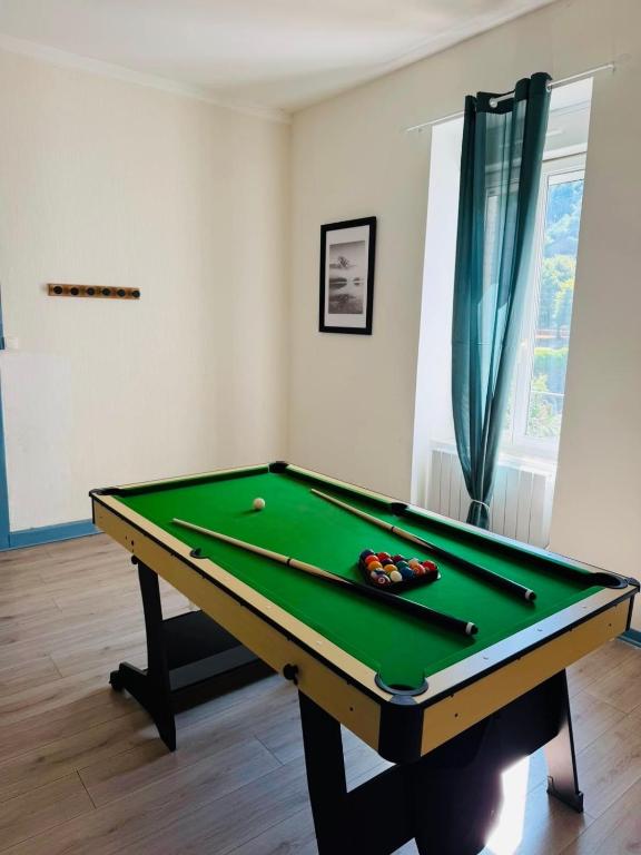 a pool table in a living room with afits at Appart cosy avec billard, à Bort in Bort-les-Orgues