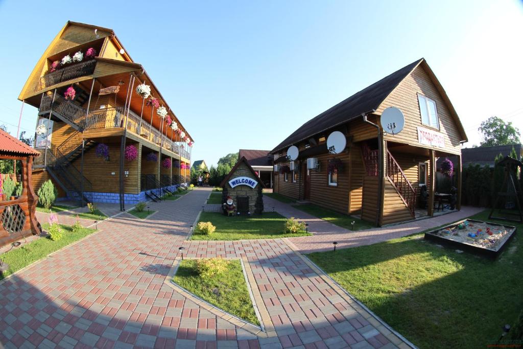 un grupo de pequeños edificios de madera en un patio en Hotel-complex Mizh Triokh Ozer en Svityazʼ