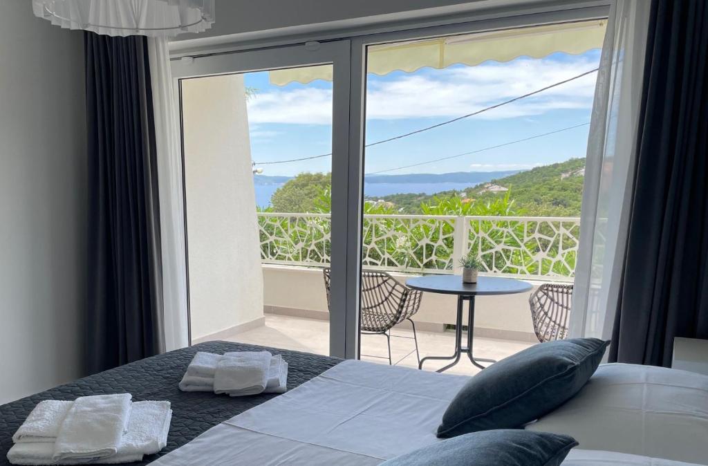 a bedroom with a bed and a balcony with a view at Apartments No26 in Povile
