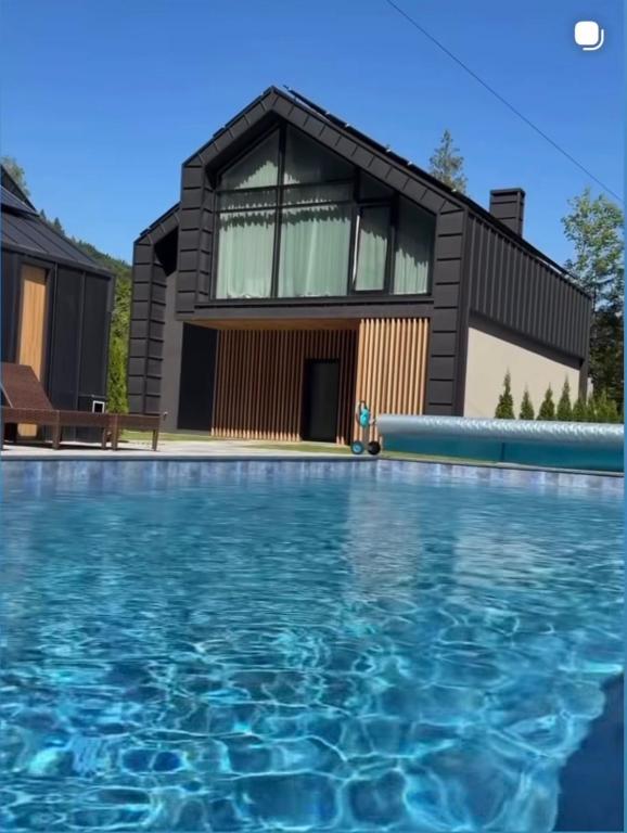 a house with a swimming pool in front of a house at GoldHill villas 9 in Yaremche