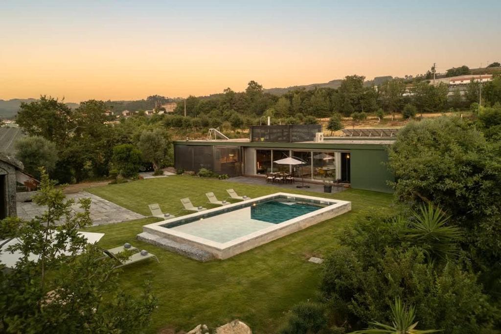a backyard with a swimming pool and a house at Stars View by Portugal Active in Fafe