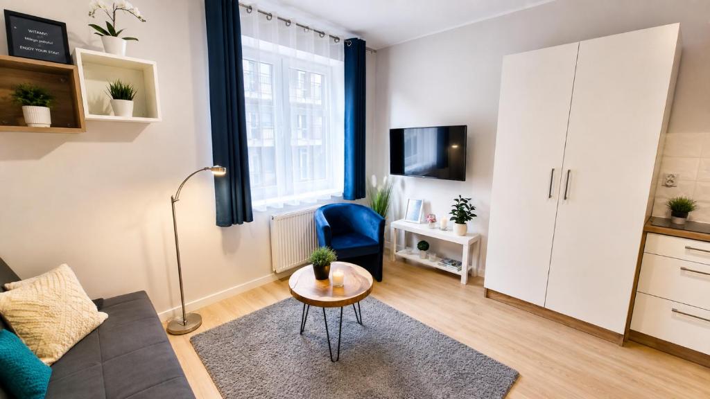 a living room with a couch and a table at Studio Cicha in Krynica Zdrój