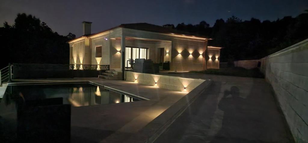 ein Haus mit Swimmingpool bei Nacht in der Unterkunft vila pico de regalados in Vila Verde