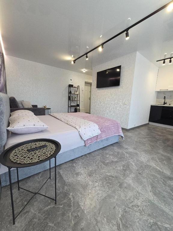 a bedroom with a large bed and a table at Апартаменты возле отеля Украина in Chernihiv