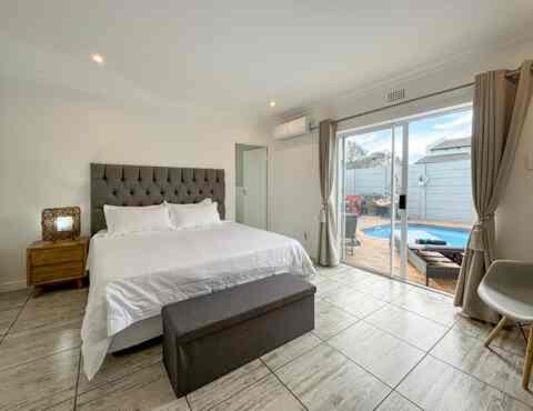 a bedroom with a bed and a view of the ocean at Vida Tranquila Guest House in Welgelegen