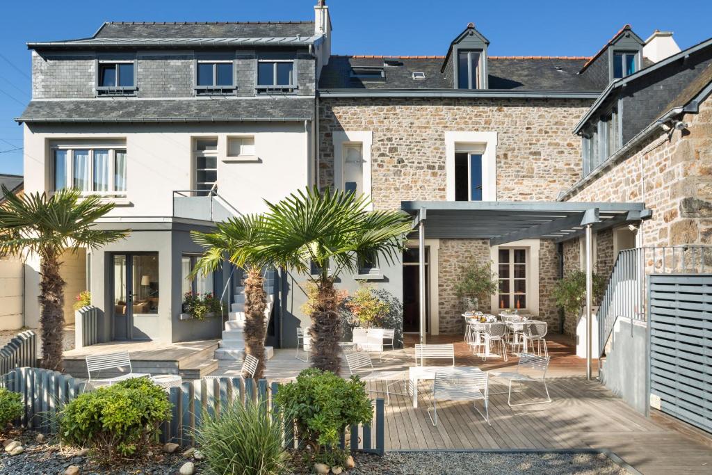 a house with a courtyard with palm trees at Hotel Eden in Saint Malo