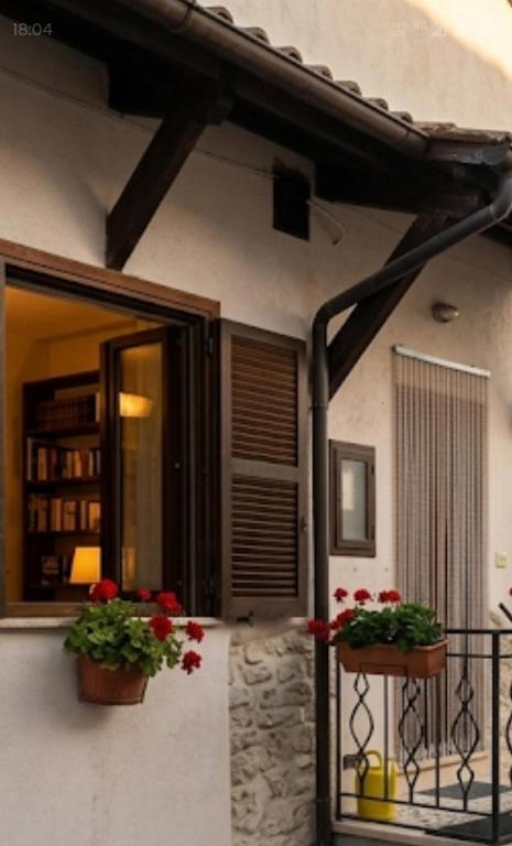a house with two flower pots on a balcony at Casa Hemingway - Casa Vacanza in Barisciano