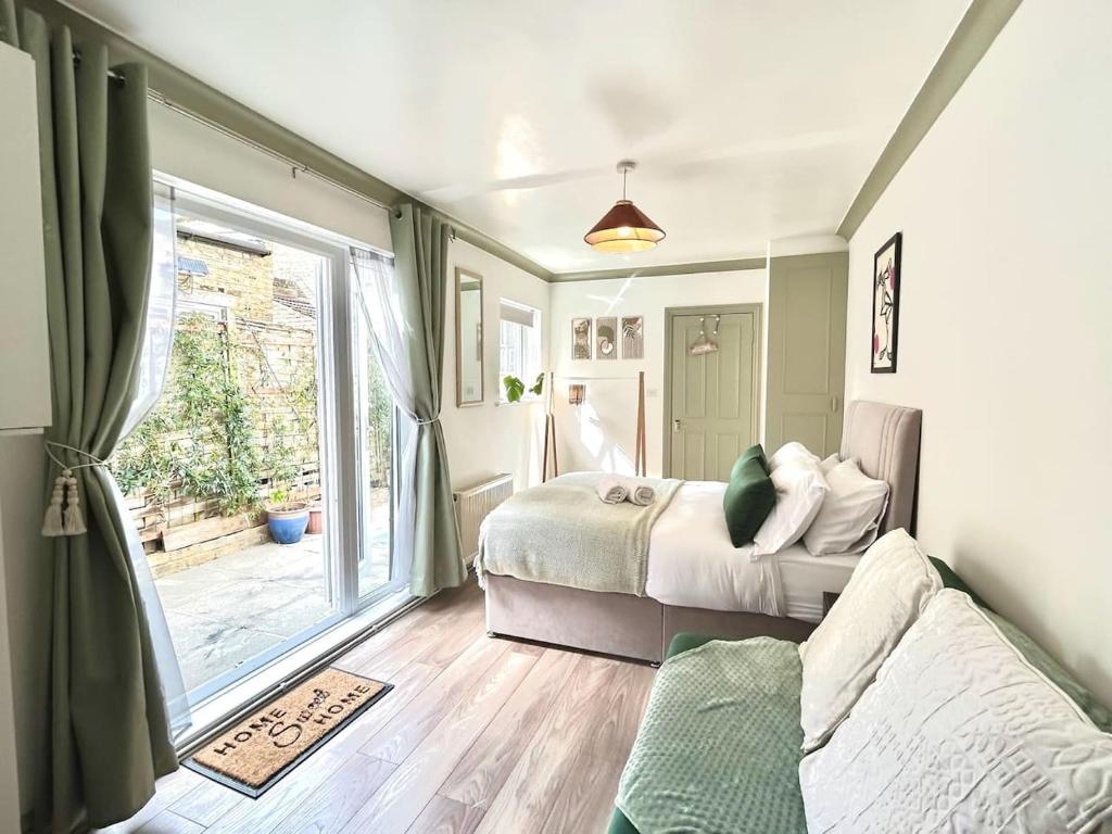 a bedroom with two beds and a large window at Courtyard Oasis in London