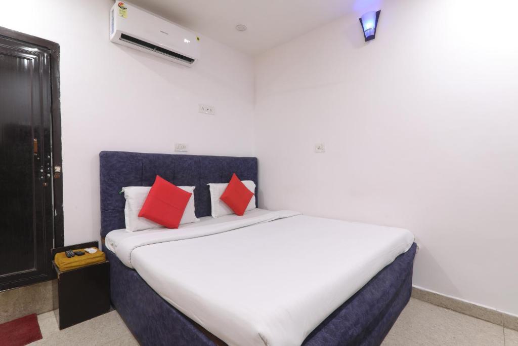 a bedroom with a large bed with red pillows at Simar Residency in Lucknow