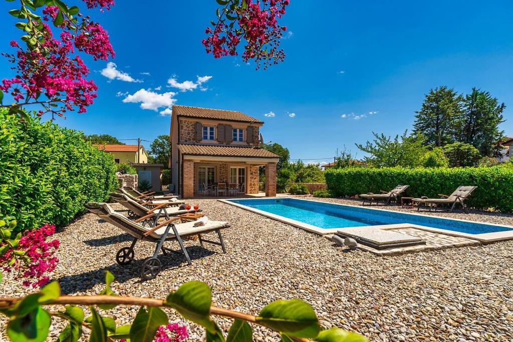 a backyard with a swimming pool and a house at Villa Pepina in Risika