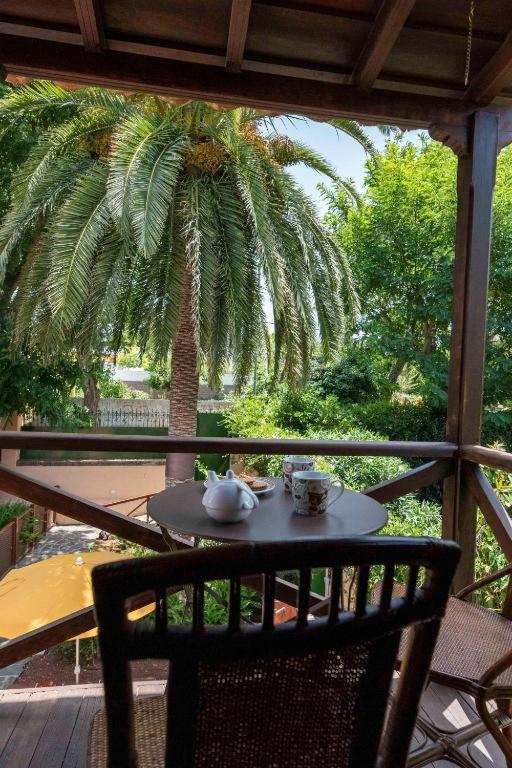 a table on a porch with a palm tree at Rincón de los Abanes - Finca Casa Jardín-VV in Las Lagunas