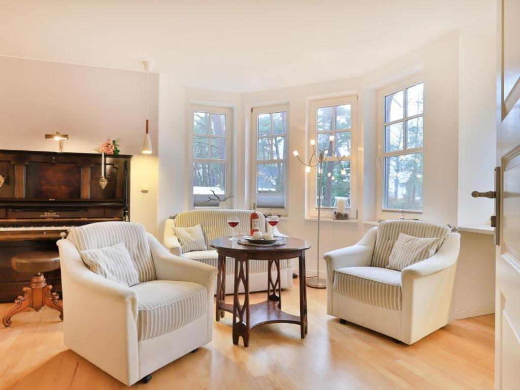 a living room with a table and chairs and a piano at Landhaus Victoria in Boltenhagen