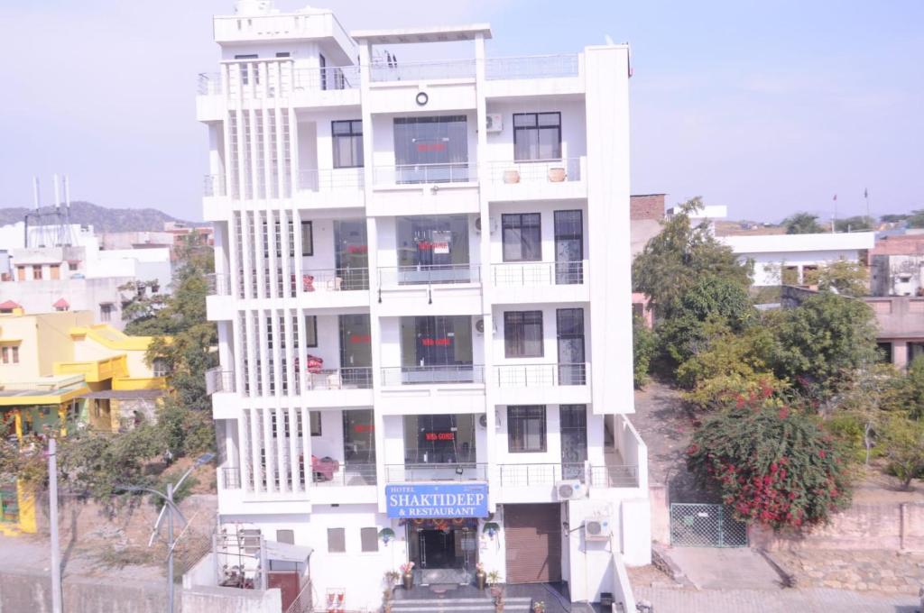 a white building with a sign in front of it at Hotel Shaktideep in Pushkar