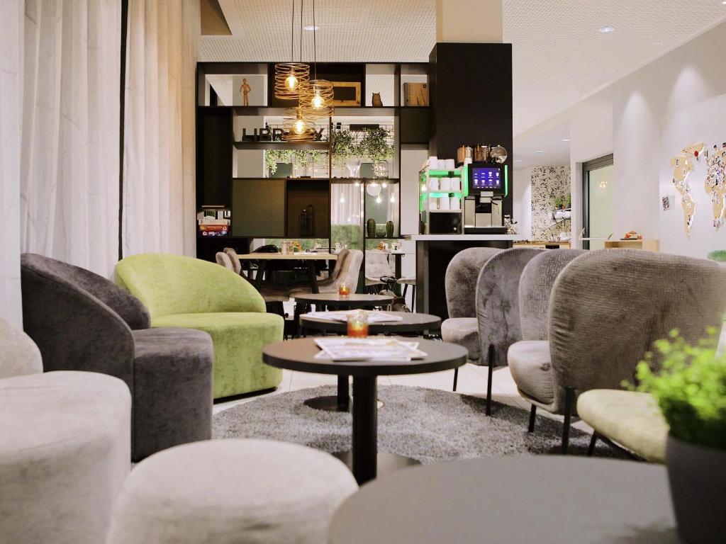 a lobby with chairs and tables and a bar at Aparthotel Adagio Access Freiburg in Freiburg im Breisgau