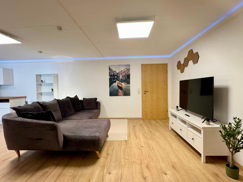 a living room with a couch and a flat screen tv at Garten-Apartment in Selm