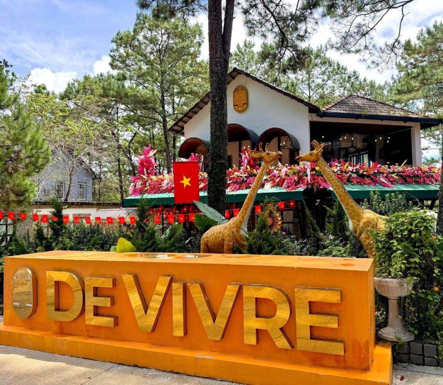 a sign with giraffes in front of a building at De Vivre Café & Home in Kon Plong