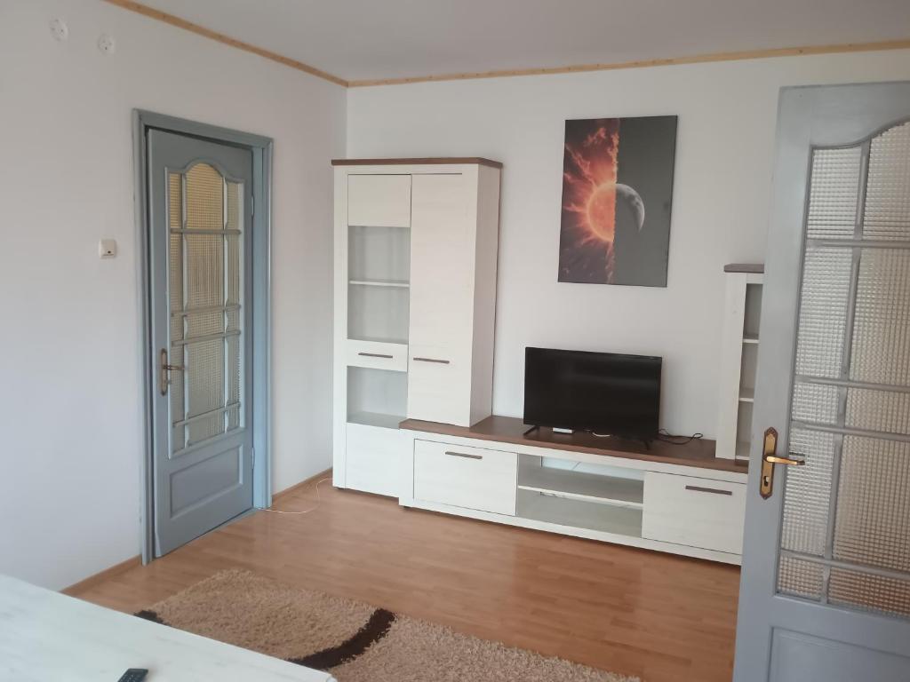 a living room with a television and white walls at Apartament Central in Piatra Neamţ