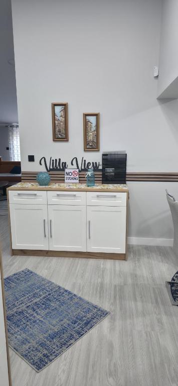 a room with two white tables and a blue rug at Villa View in Neum