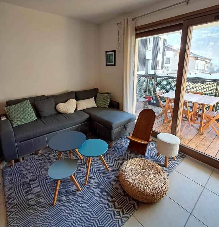 a living room with a couch and tables and a balcony at Modern appartmenr in Bozel