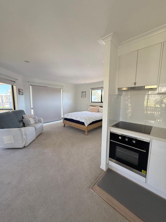 a living room with a couch and a bed at Beachside Studio Apartment in Bargara