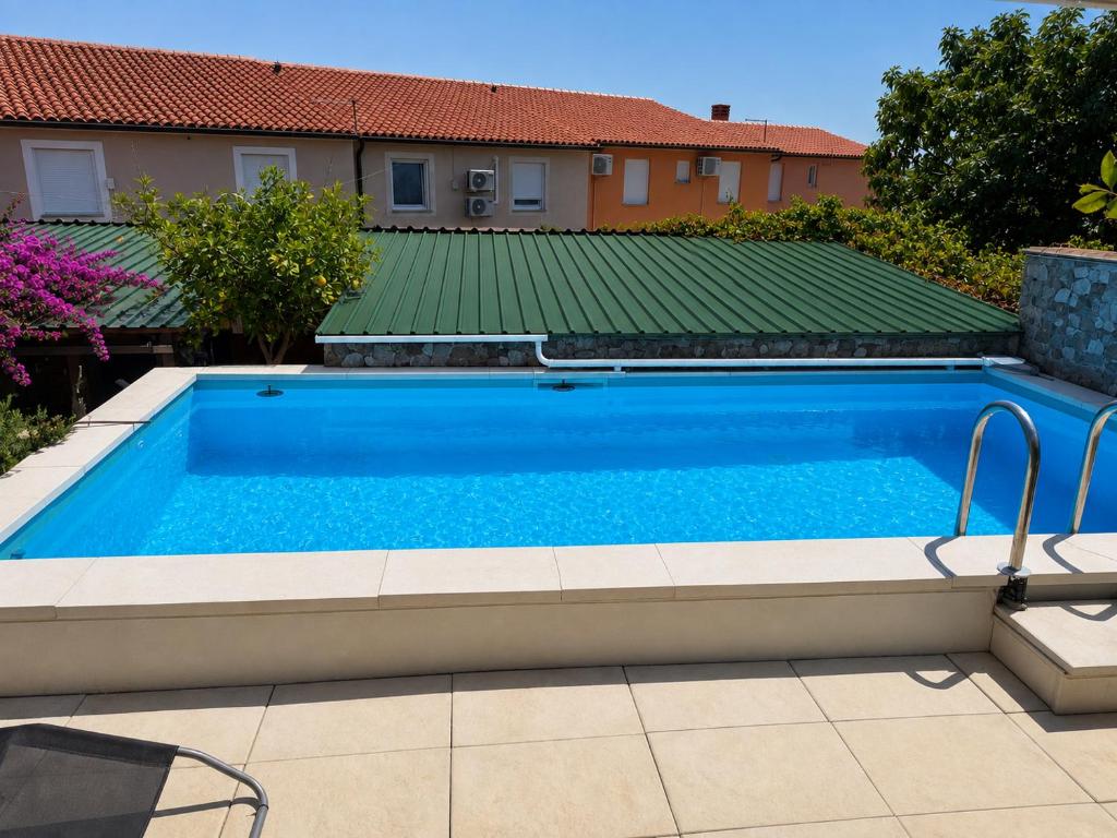 a swimming pool in front of a house at Zupan apartments in Ližnjan