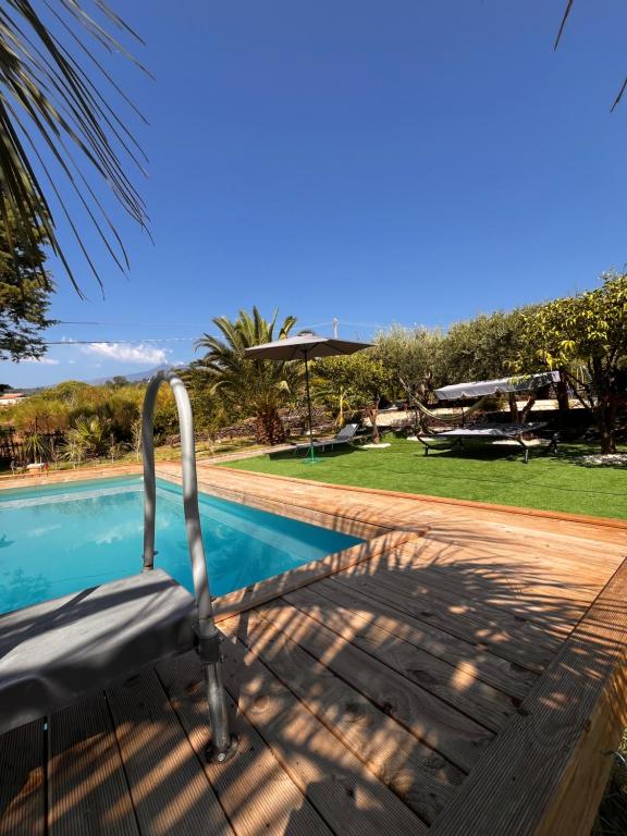 a chair sitting next to a swimming pool at Villa Etna Maison in Montargano