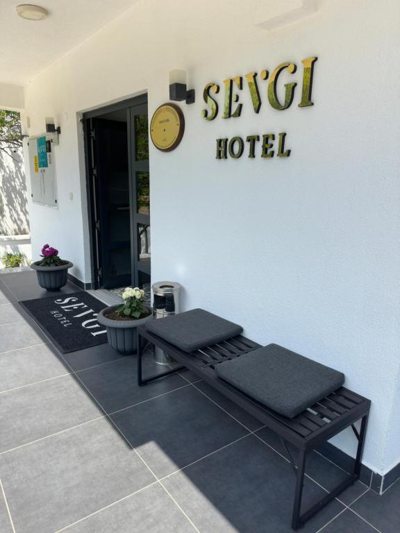 a hotel lobby with a bench and a clock on the wall at Sevgi Hotel in Ezine