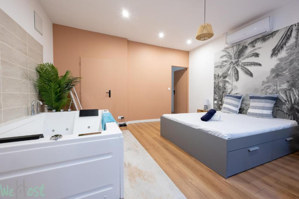 a bedroom with a large bed and a bathroom at Charmant cocon avec jacuzzi - Bordeaux Centre in Bordeaux