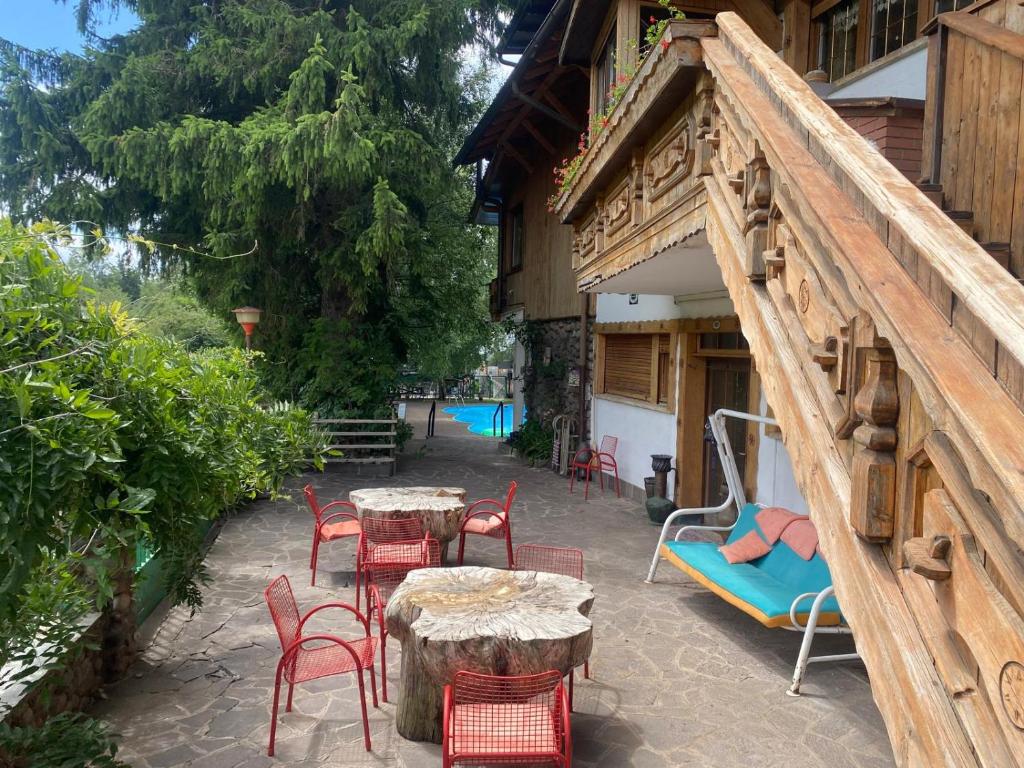 a patio with tables and chairs and a building at Albergo Garni Villa Lory in Baselga di Pinè