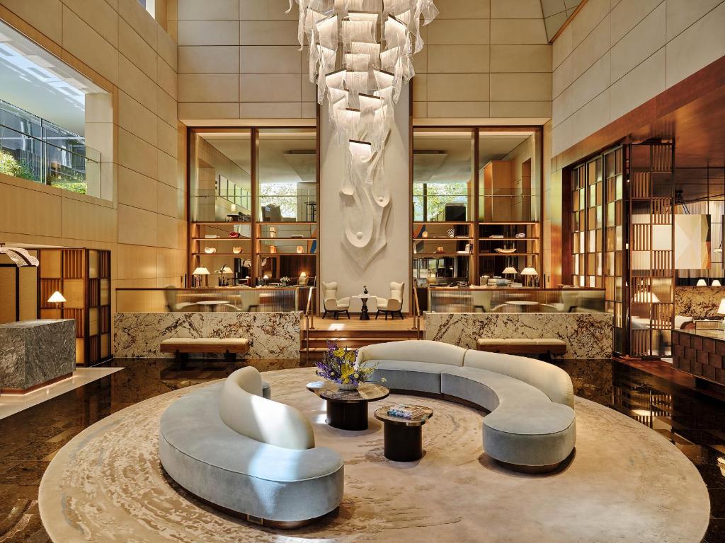 a lobby with couches and a chandelier in a building at Park Hyatt Zurich – City Center Luxury in Zurich