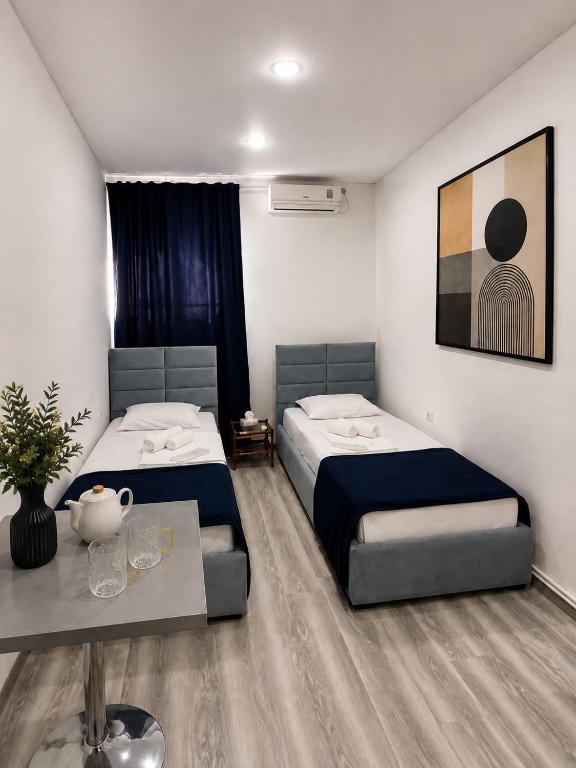 a bedroom with two beds and a table in it at White Hotel in Yerevan