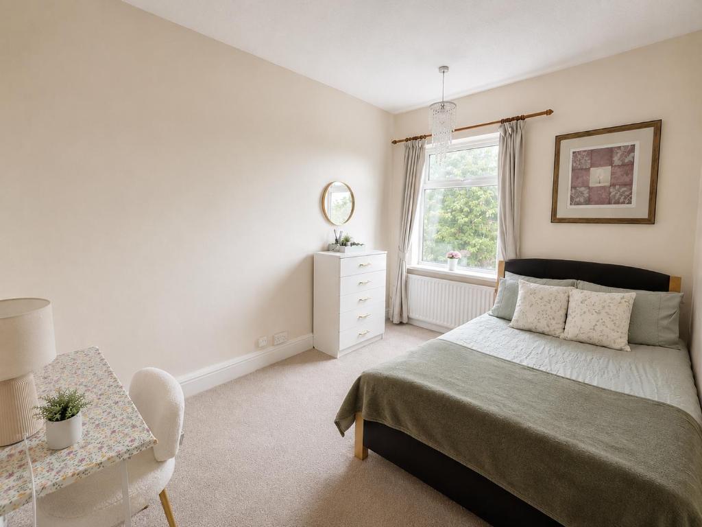 a bedroom with a bed and a dresser and a window at Spacious Double Room In Central Stoke in Stoke on Trent