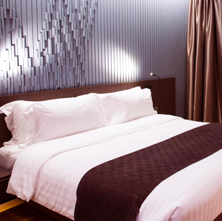 a bedroom with a large bed with white sheets at Laura Camp side Udawalawe in Udawalawe