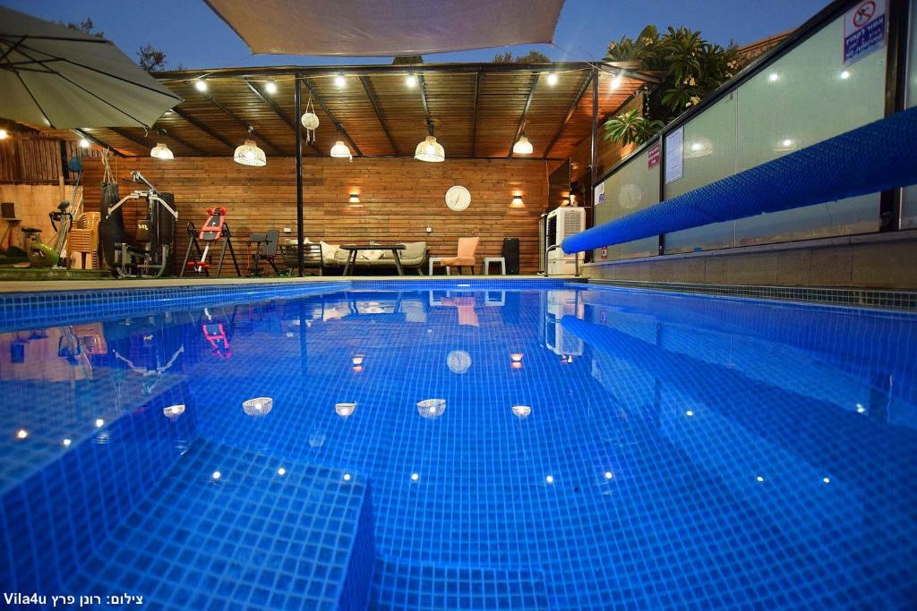 a large swimming pool with blue tiles on it at סוויטה בכפר ירכא in Yarka