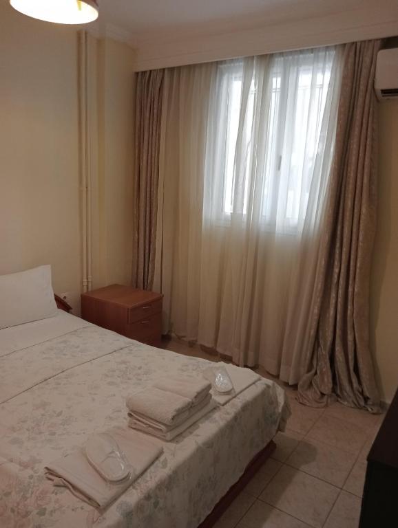 a bedroom with a bed and a window with towels on it at Stydio Damos in Kavála