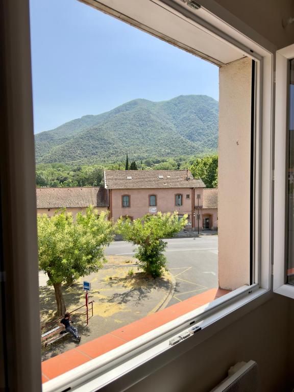 a window with a view of a street and mountains at Maison classée 3 étoiles avec garage et 2 terrasses in Arles-sur-Tech