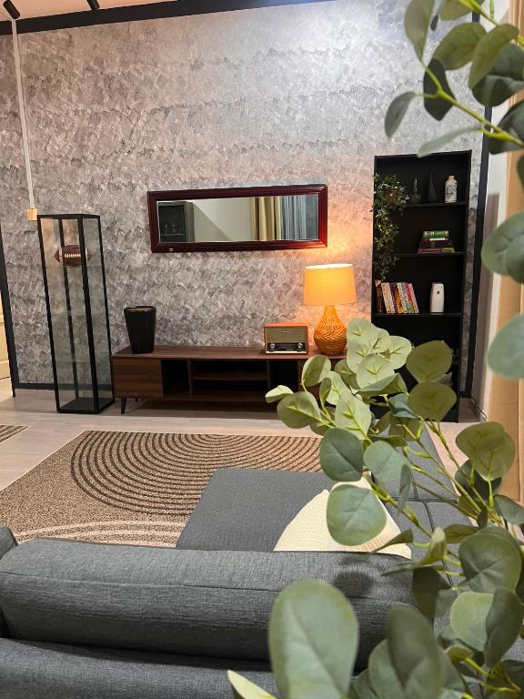 a living room with a couch and a mirror at The Teduh Homestay By Rumah Mimpi in Kertih