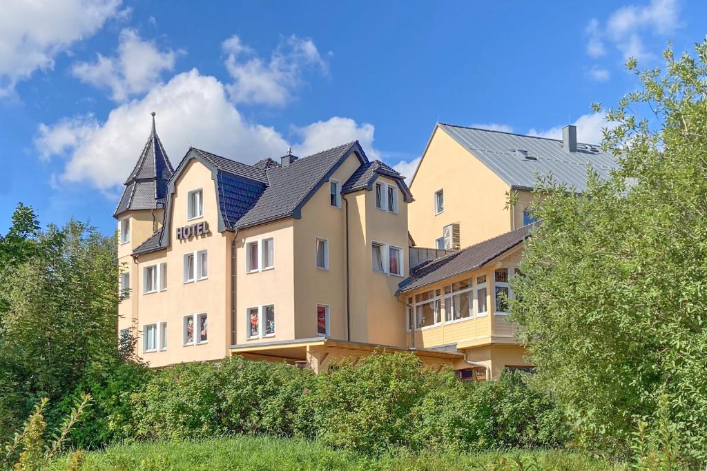 a large yellow building with a black roof at Schlossberghotel Oberhof in Oberhof
