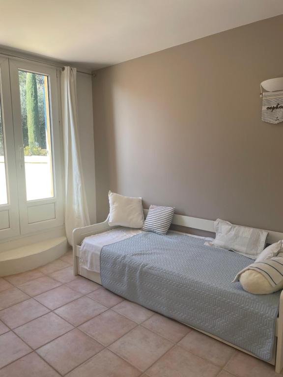 a bedroom with a bed with pillows and a window at Mas Elaia in La Farlède