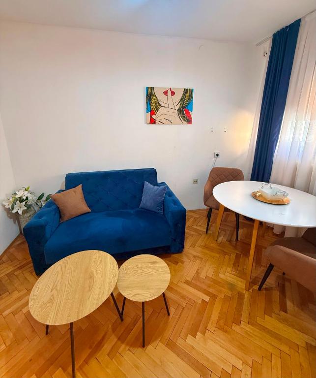 a living room with a blue couch and a table at Apartment CenterZeroZone in Banja Luka