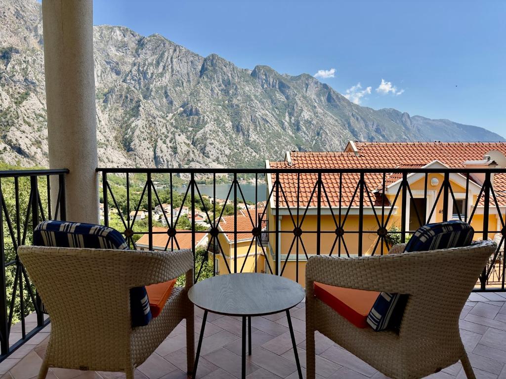 a balcony with two chairs and a table and mountains at GH Mountain & Bay View with POOL in Gornji Orahovac