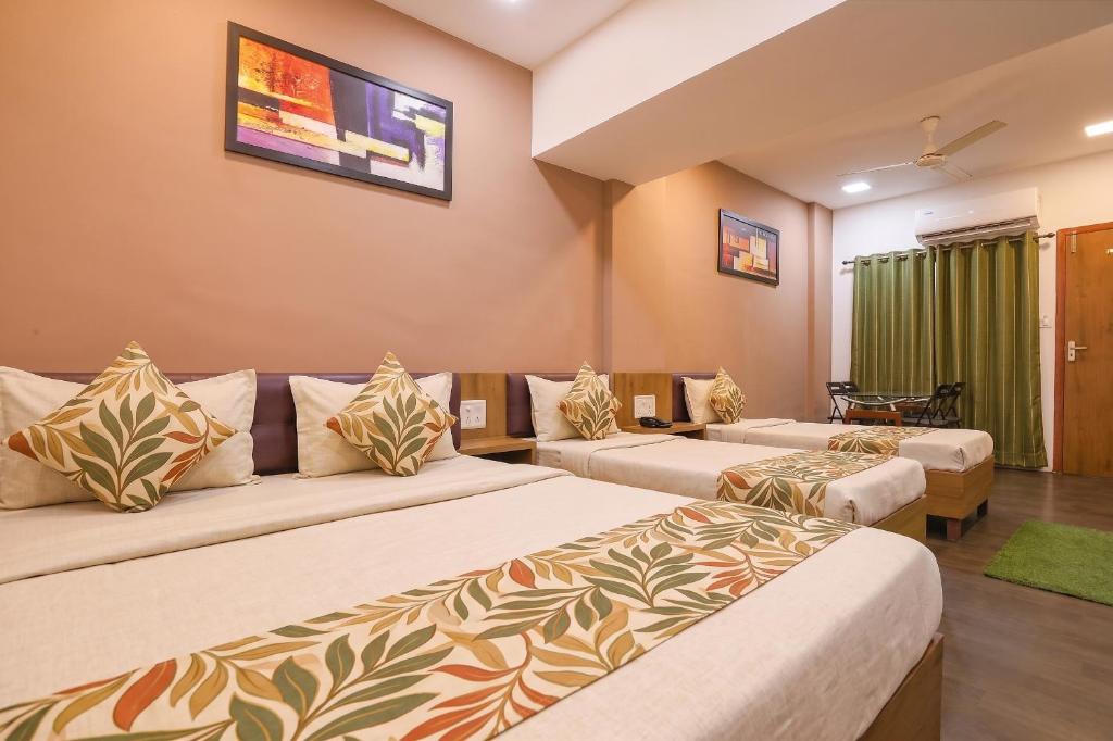 a living room with two beds and a couch at FabHotel Maple Leaf in Hyderabad