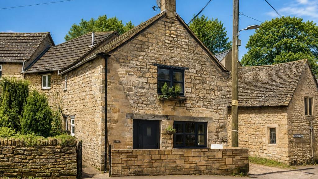 an old stone house with a brick wall at Cotswold Way Cottage in Stroud