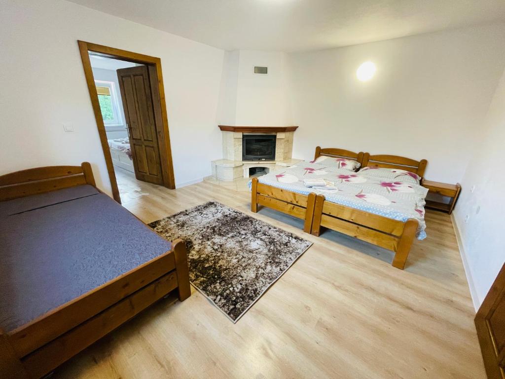a bedroom with two beds and a fireplace at Apartmány Bartoš Vitanová in Vitanová