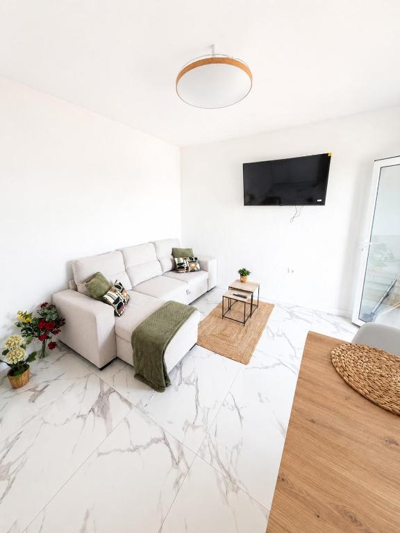 a white living room with a white couch and a table at Nido del Sol in Guía de Isora