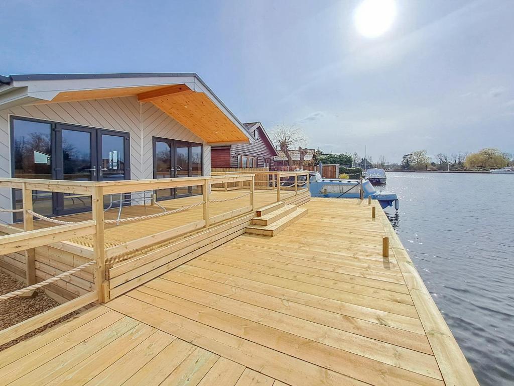 a large wooden dock with a house on the water at Nature's Nook in Brundall