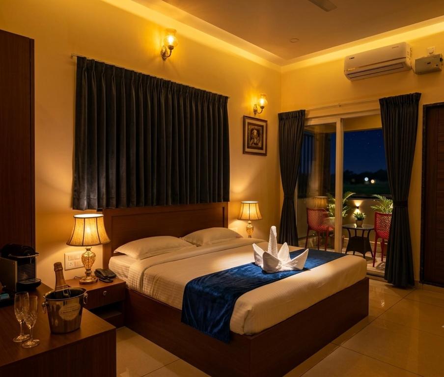 a bedroom with a large bed and a window at Hotel Srirangasthalam in Chitradurga