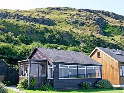 a small house in front of a mountain at Braemar in Lendalfoot
