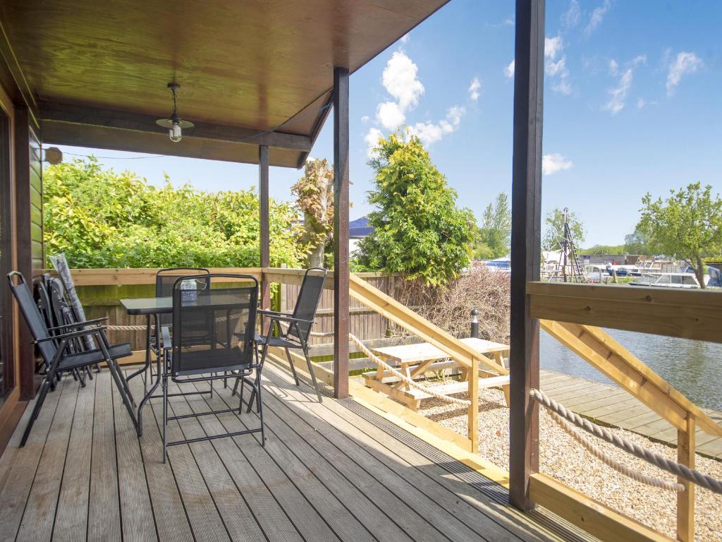 a porch with a table and chairs on the water at River Rest-B6863 in Brundall